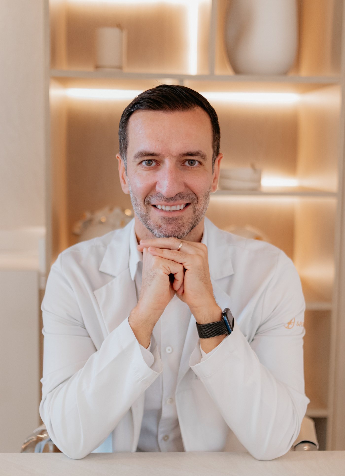 Dr. Thiago Diaz em retrato profissional no consultório, de jaleco.